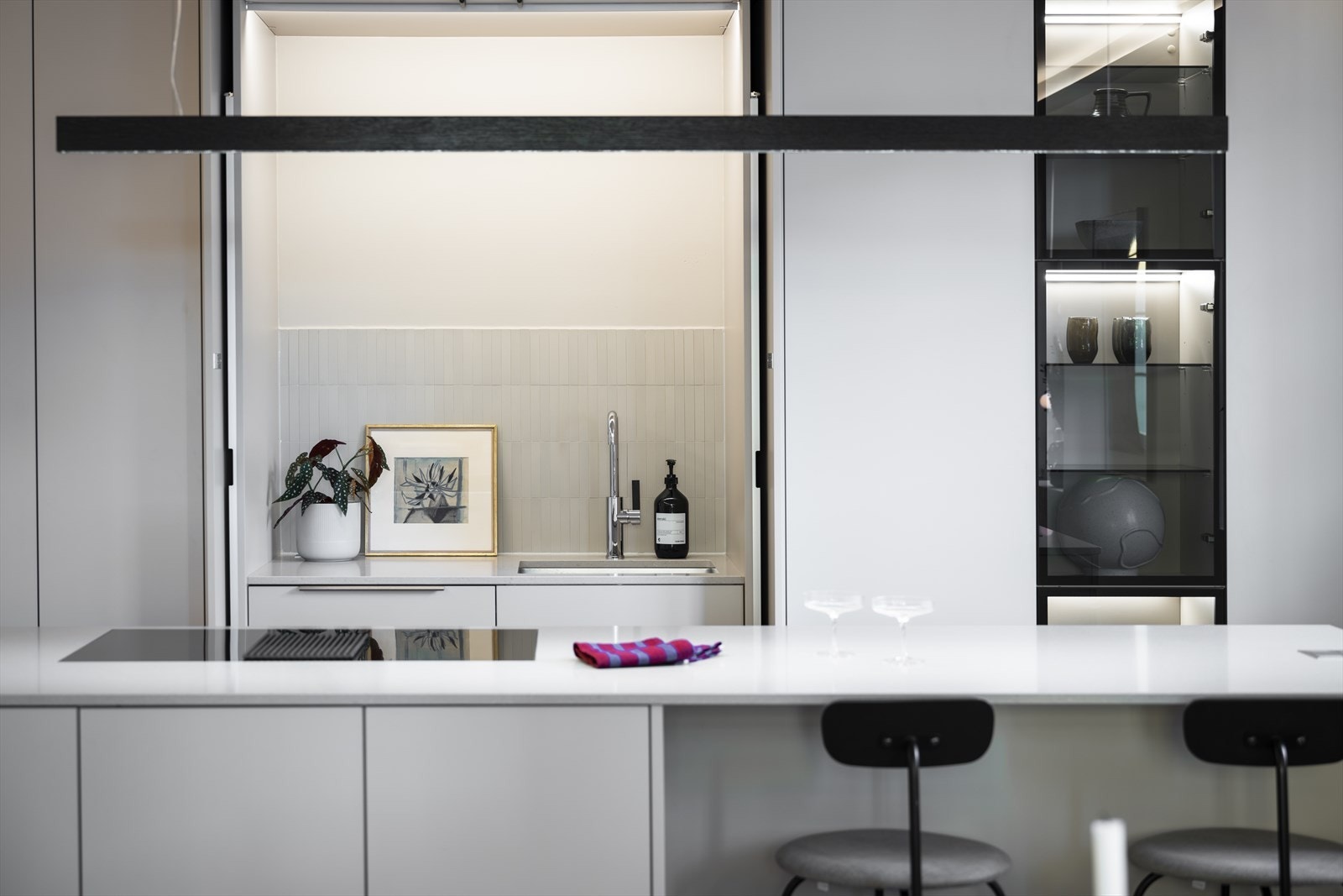 Det er mulighet for å "lukke av vask/kum-delen" med store skapdører som gjør hele inntrykket av kjøkkenet meget elegant, stilrent og sømløst Galleribilde