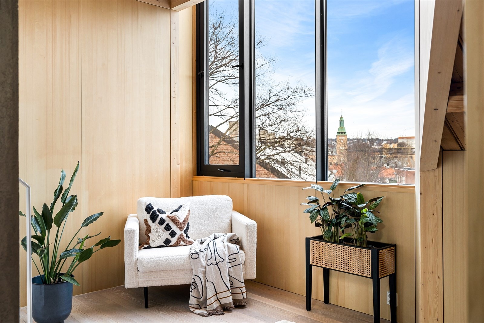 Loftsstuen møtes med takhøye vindusflater i sort funkis-stil og slette panelplater som gir et kult og varierende uttrykk Galleribilde