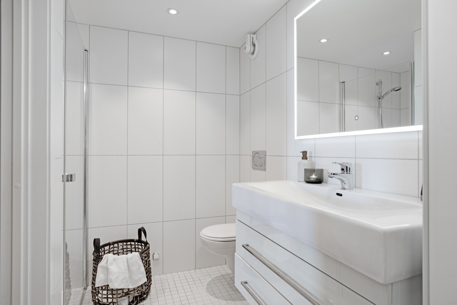 Badet er utstyrt med downlights i himling, opplegg for vaskemaskin, veggmontert wc og varmekabler i gulv Galleribilde