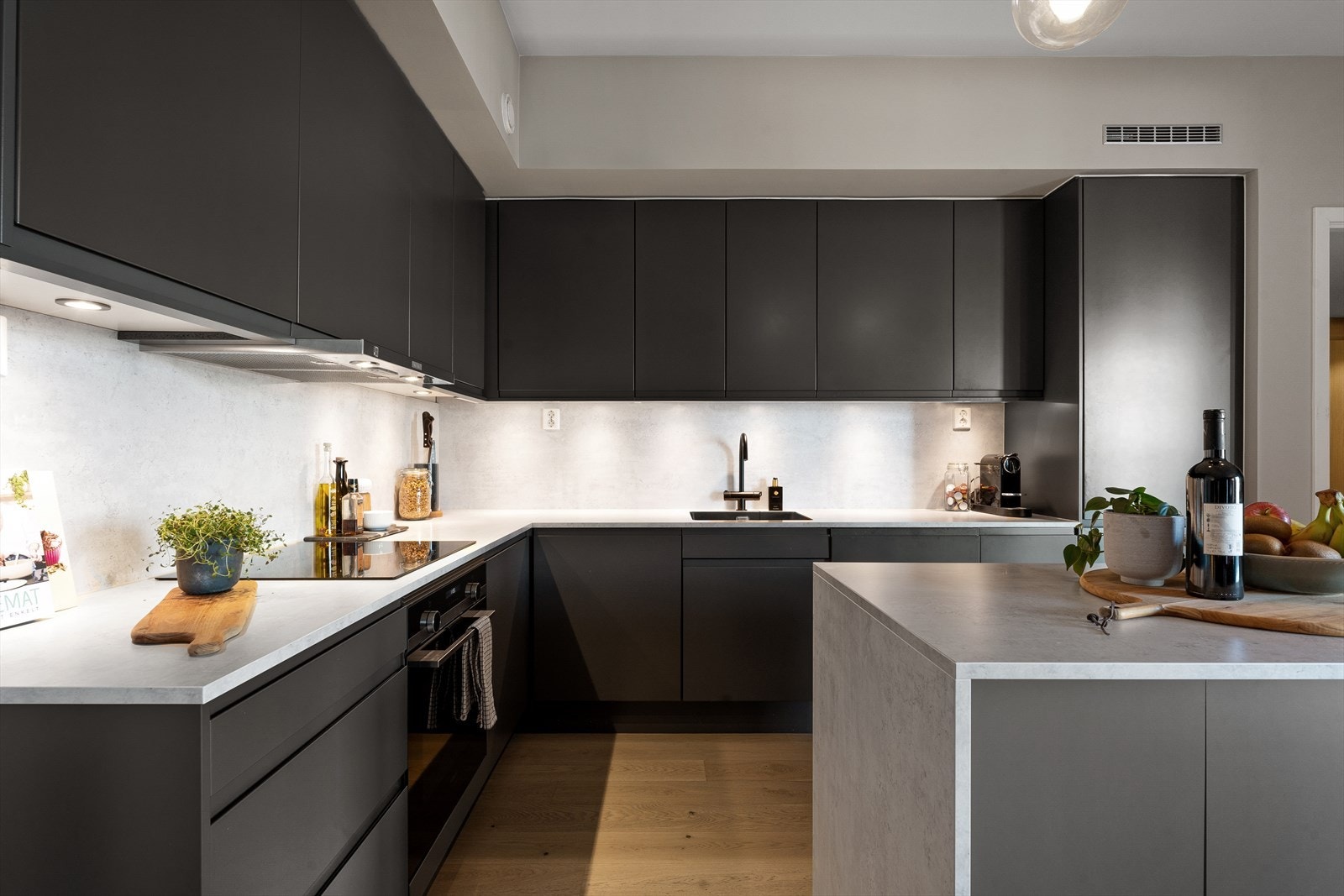 Stilrent og moderne kjøkken fra Sigdal med laminat benkeplate og bakplate samt integrerte hvitevarer fra Siemens studioLine. Galleribilde