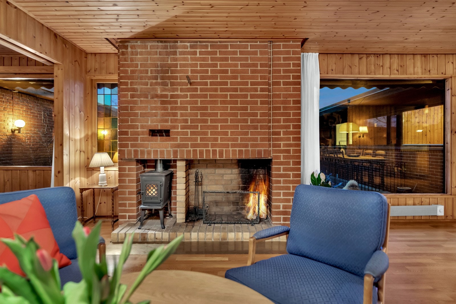 Ved en oppmurt peis er det plass til sofagruppe og tilhørende møblement, og i nærheten av kjøkkenet er det rom for å samle familie og venner rundt et stort spisebord. Galleribilde