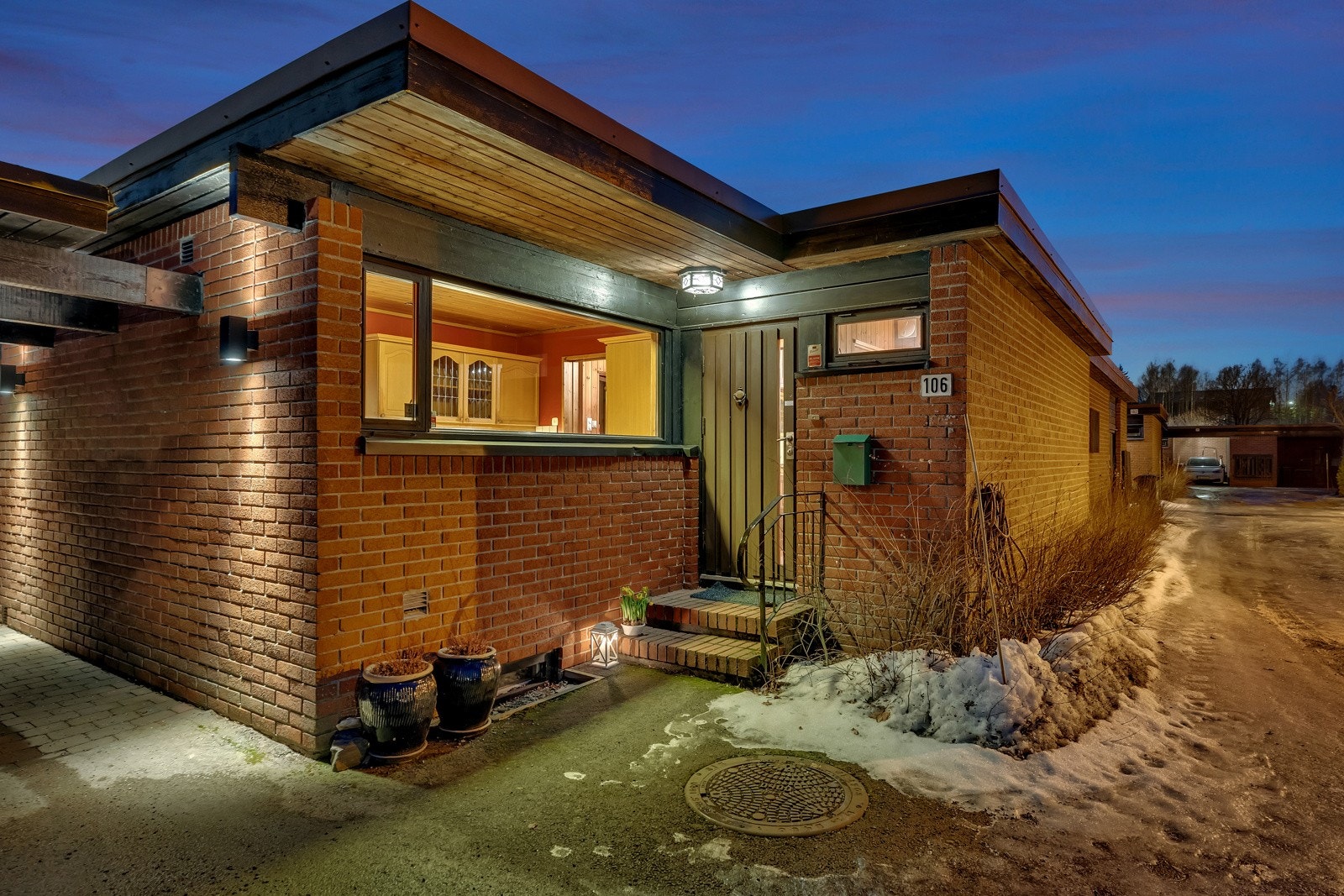 Boligen har et pent, overbygd inngangsparti med asfaltert adkomst, støpt trapp og takmontert utebelysning Galleribilde