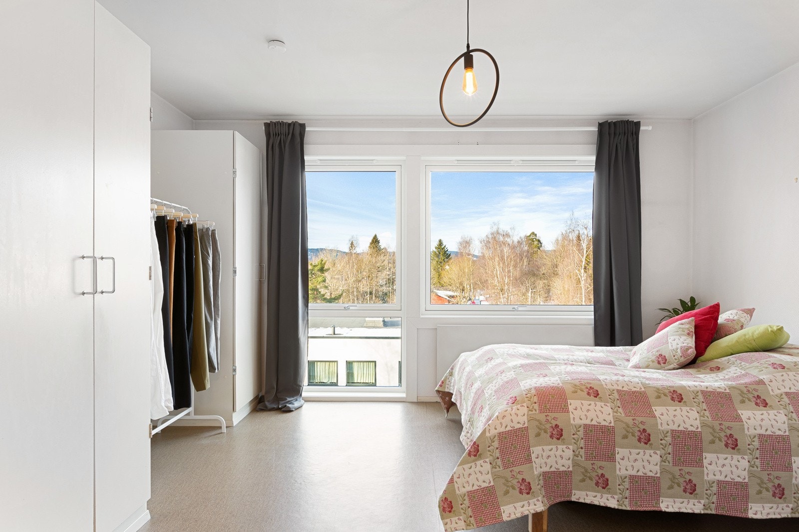 Soverommet holdes enkelt ryddig ved hjelp av to hvite, doble garderobeskap. Galleribilde