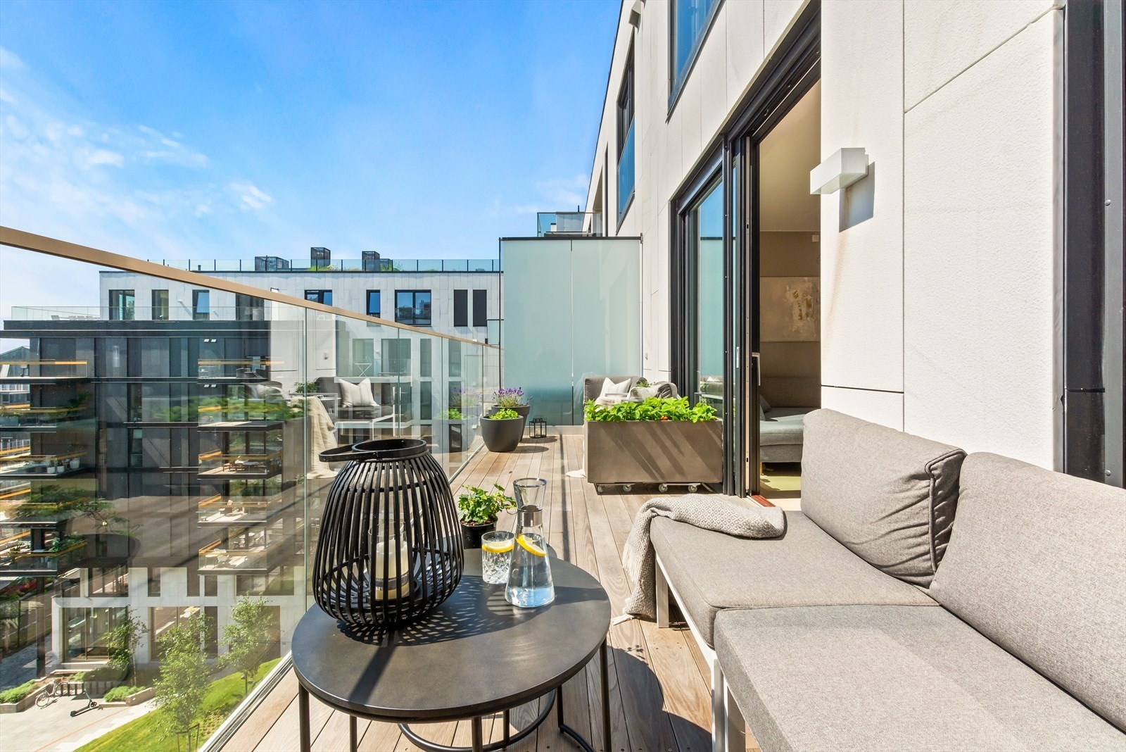 Solrik balkong på hele 14 m² med utebelysning, trespaltet gulv og god plass til utemøbler, beplantning og folk Galleribilde