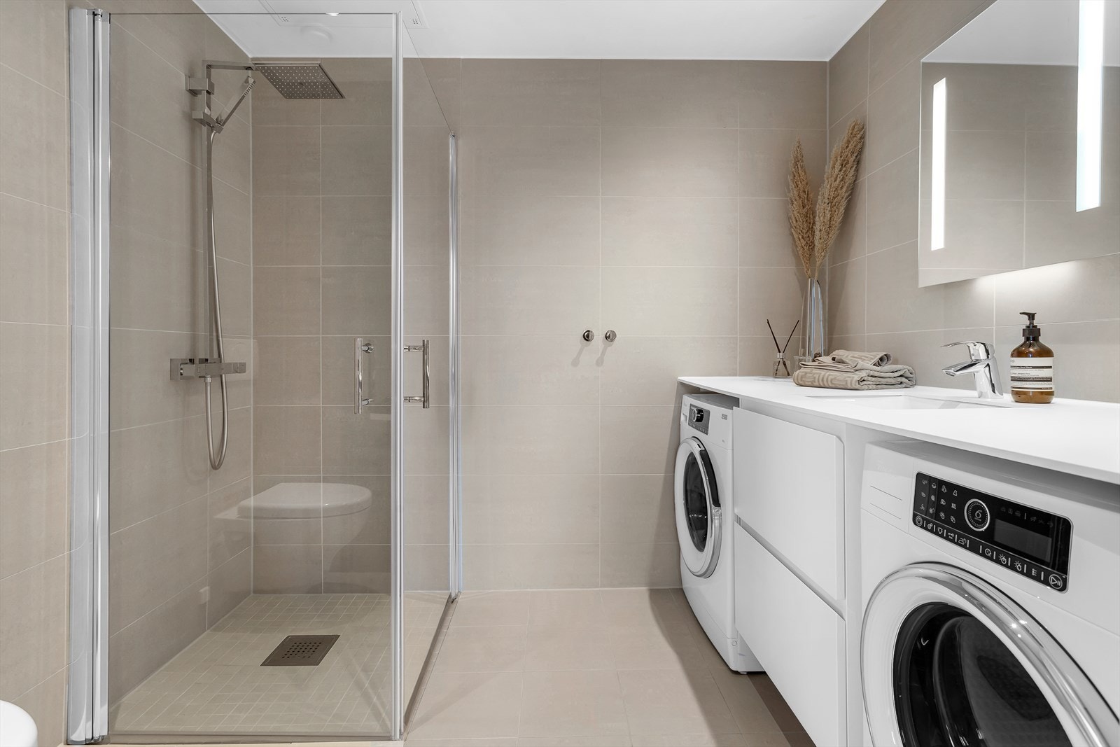 Delikat flislagt bad med varmekabler og downlights. Dusjhjørne med dører i herdet glass Galleribilde