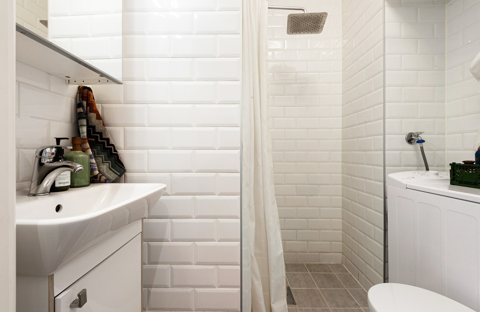 Badet er innbydende med plass til oppbevaring, dusj, toalett, servant og oppbevaring. Galleribilde