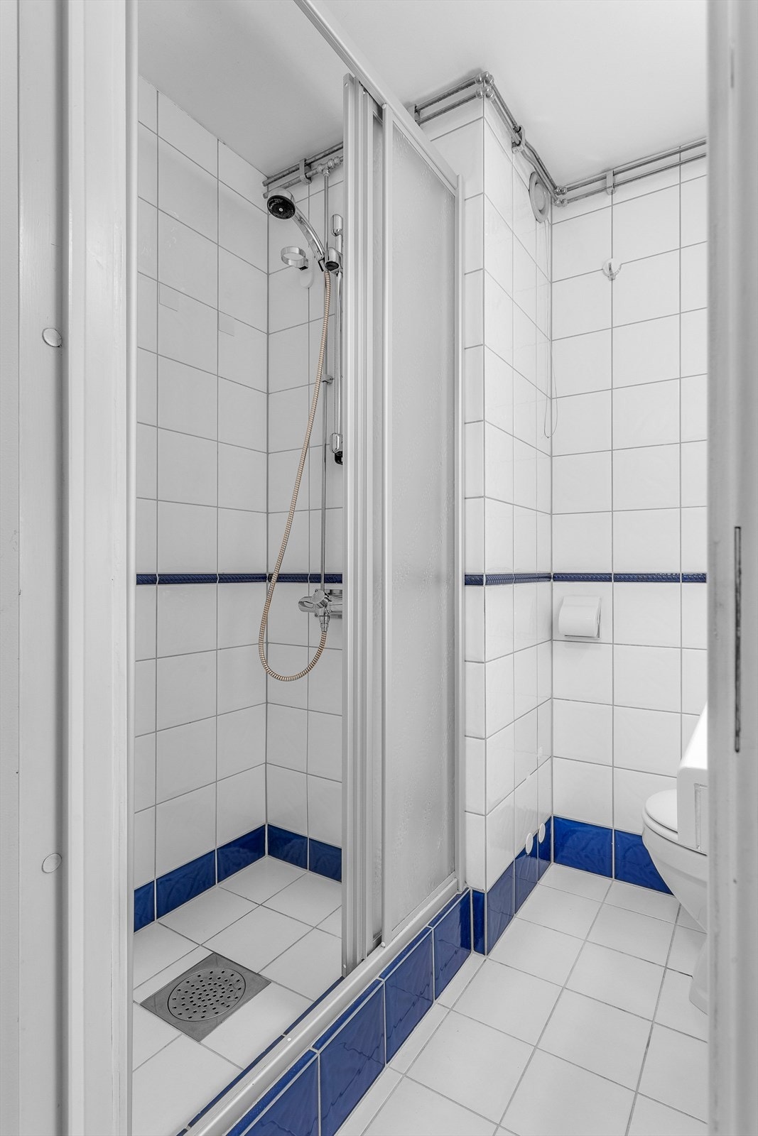 Dusj med skyvedør. Fliser på gulv og på vegger. Galleribilde