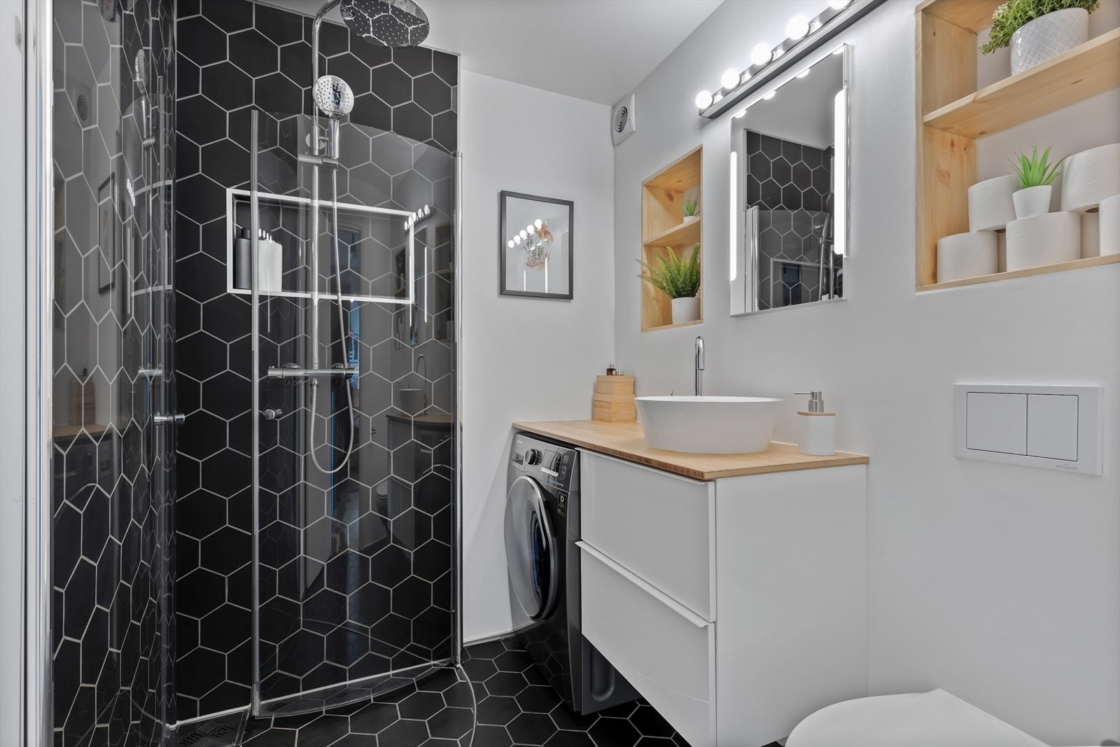 Svingbare dusjdører sørger for maksimal utnyttelse av baderommet. Det er også laget til en fin nisje til servant og vaskemaskin. Galleribilde