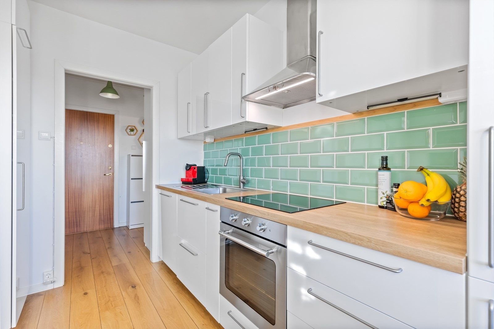 Kjøkkenet som resten av boligen har gode løsninger for oppbevaring, høyskap på venstre side er svært nyttig for lagring av diverse kjøkkenredskaper. Ellers er det benyttet pene fliser til dekorasjon mellom overskap og benkeplate. Galleribilde