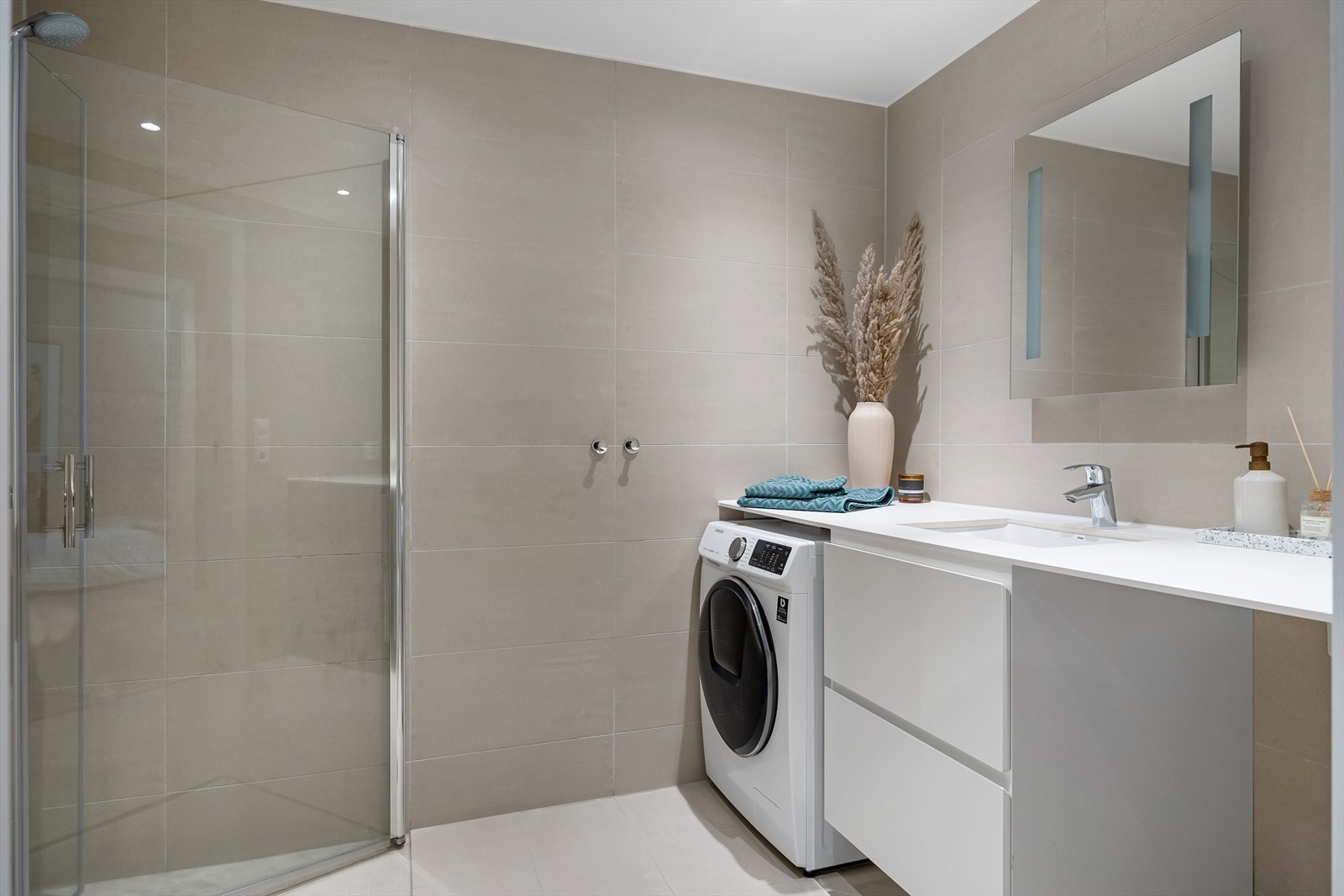 Pent flislagt bad med varmekabler i gulvet. Heldekkende servant på underskap, speil og belysning. Galleribilde