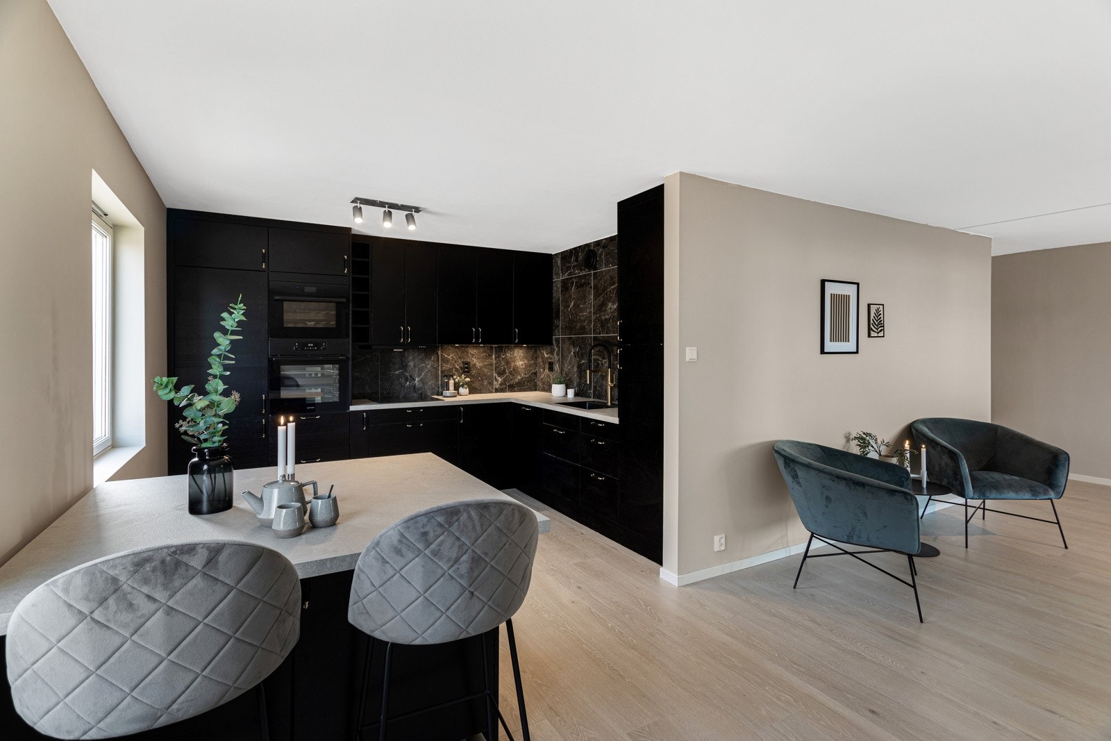 Den takhøye innredningen har mørke, glatte fronter, mørk oppvaskkum og stilrene gulldetaljer som gir et eksklusivt inntrykk. Galleribilde