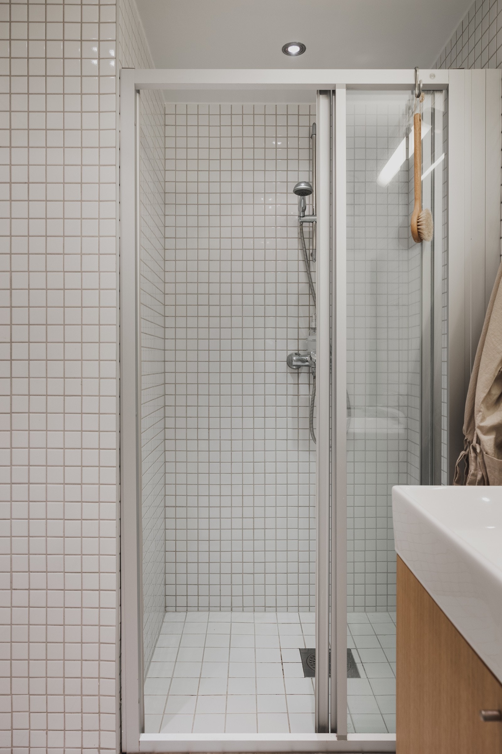 Badet er helfliset med dusjnisje med glassdør Galleribilde