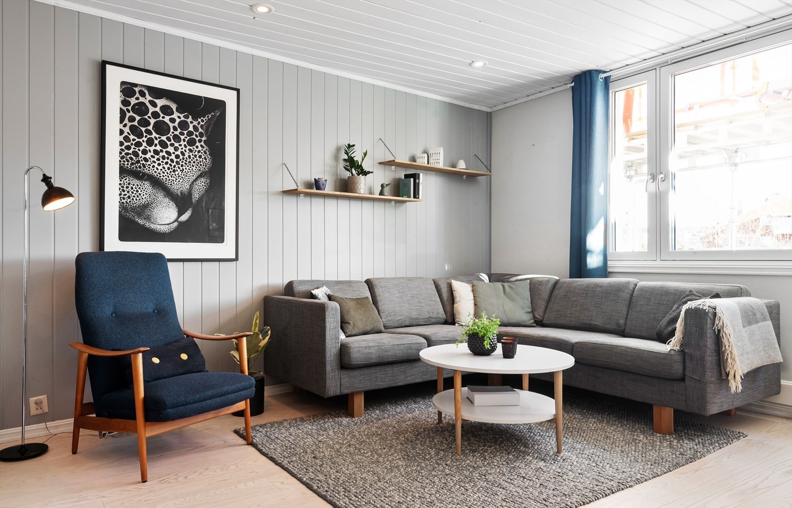 Stue med utgang til balkong. Det er satt opp stillaser utenfor balkongen som følge av pågående takrehabilitering. Galleribilde