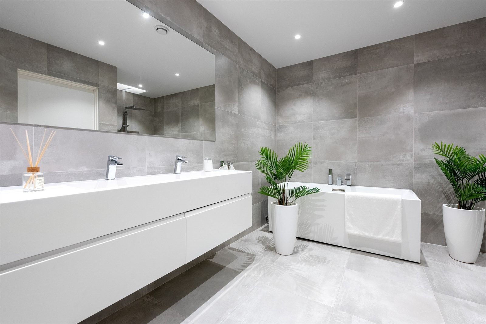 Flislagt bad i 1. etasje. 60 x 60 fliser fra Modena. Innredning med speil og badekar. Ledspotter i tak. Galleribilde