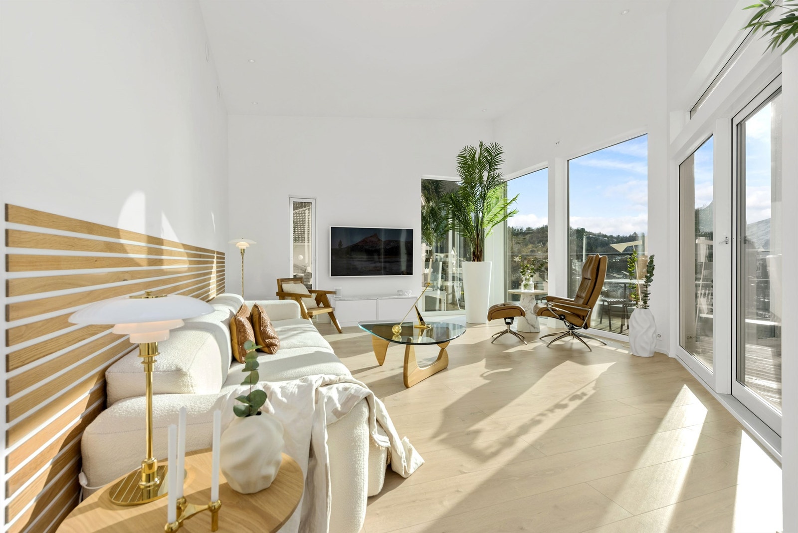 Lys og lekker stue med eikespiler og store vindusflater Galleribilde