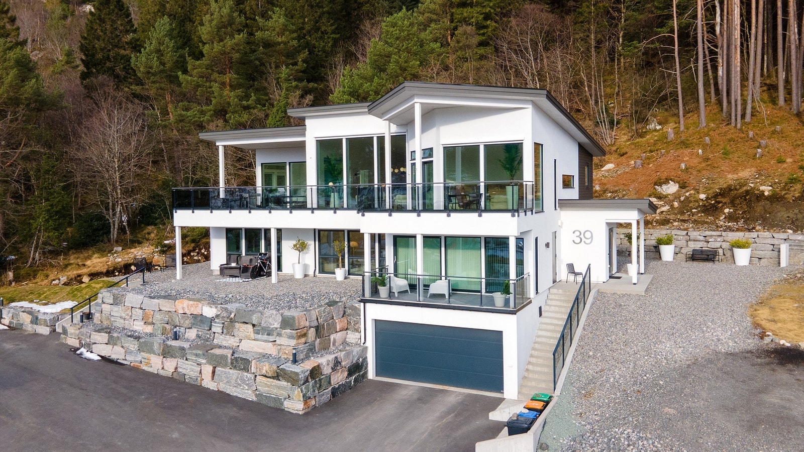 Fasade og garasje. Asfaltert biloppstillingsplass og flere uteplasser Galleribilde