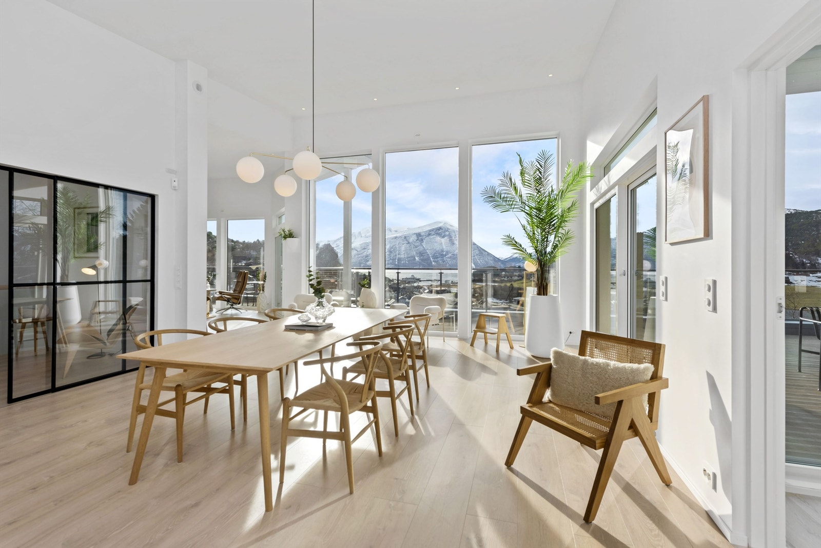 Spisestue med svarte glassdører til gang. Store vinduer og god takhøyde Galleribilde