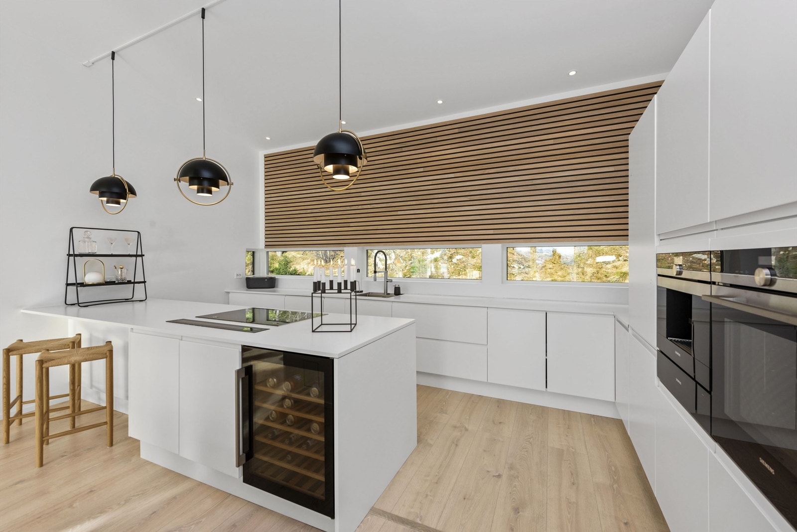 Lekkert kjøkken med barløsning og integrerte hvitevarer. Gjennomført skandinavisk stil i hele boligen. Legg merke til spileveggen i eik. Galleribilde