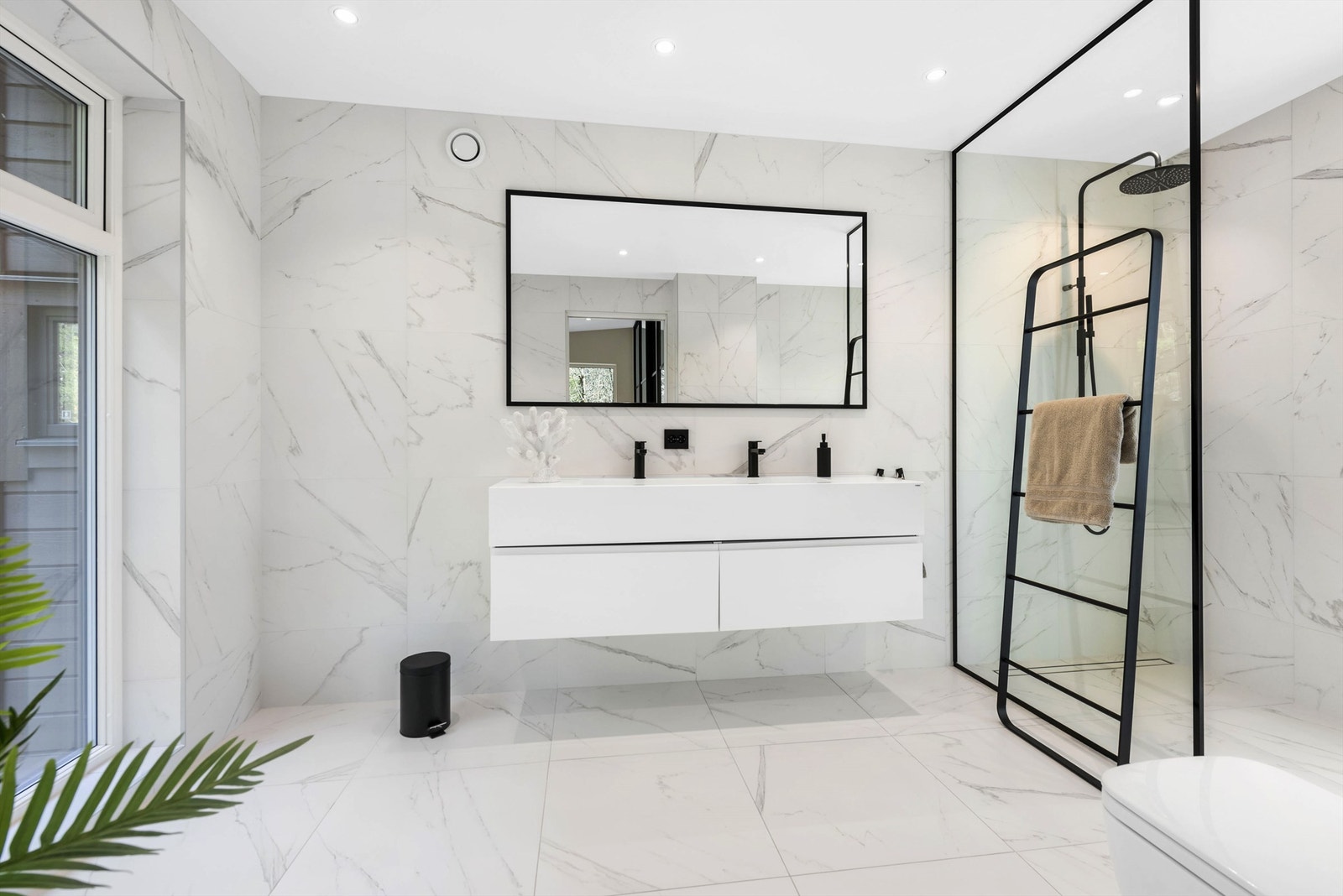 Lekkert bad i tilknytning til hovedsoverom. Glassvegg med svart ramme. Galleribilde