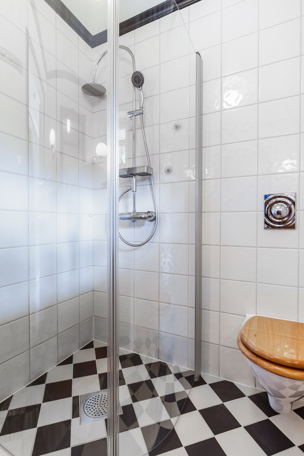 Badet inneholder vegghengt toalett, dusjnisje, servant med underskap og sideskap Galleribilde