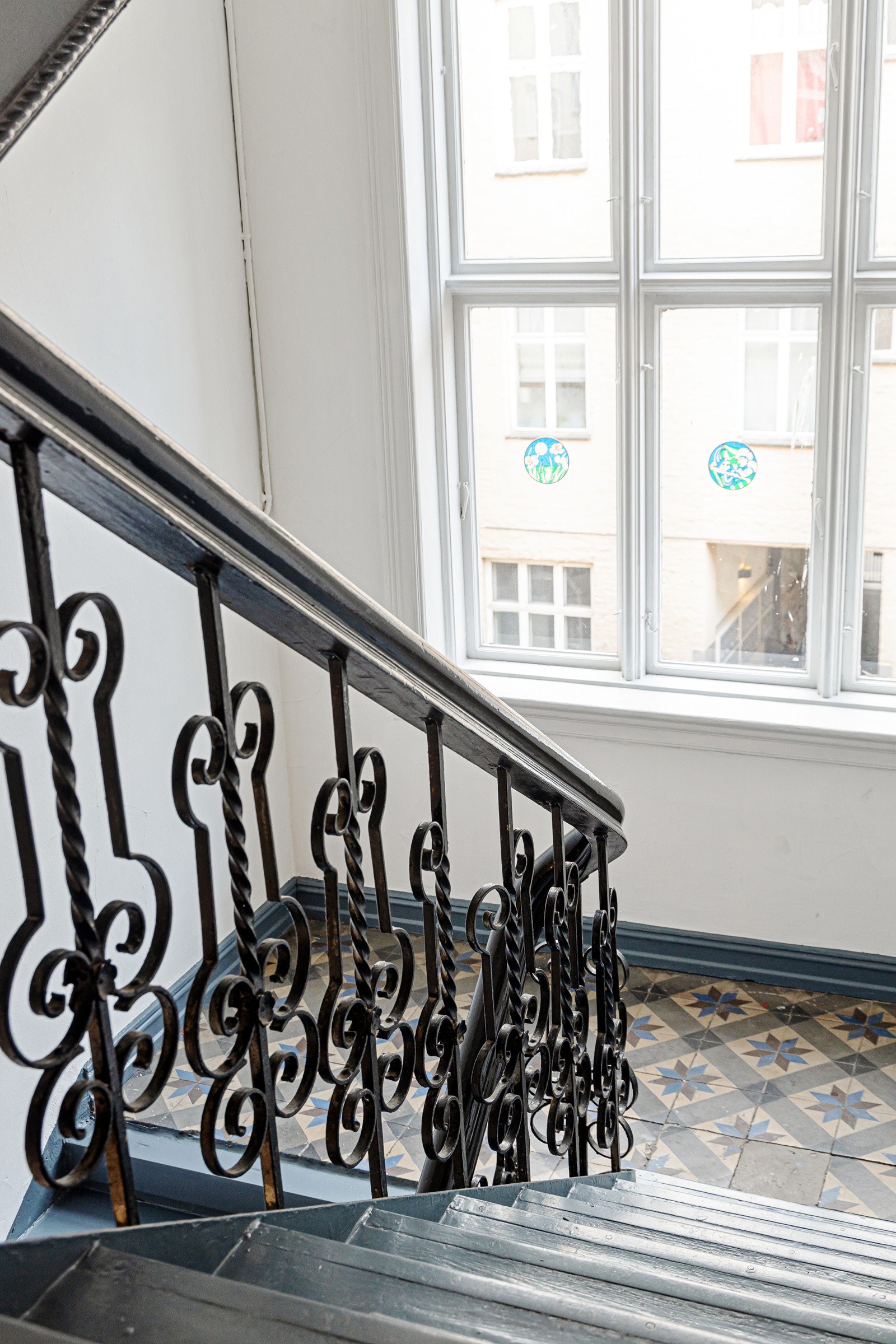Adkomst til leiligheten via felles oppgang som ble pusset opp i 2020, og støpejernstrapp med malte trinn og reposer. Galleribilde