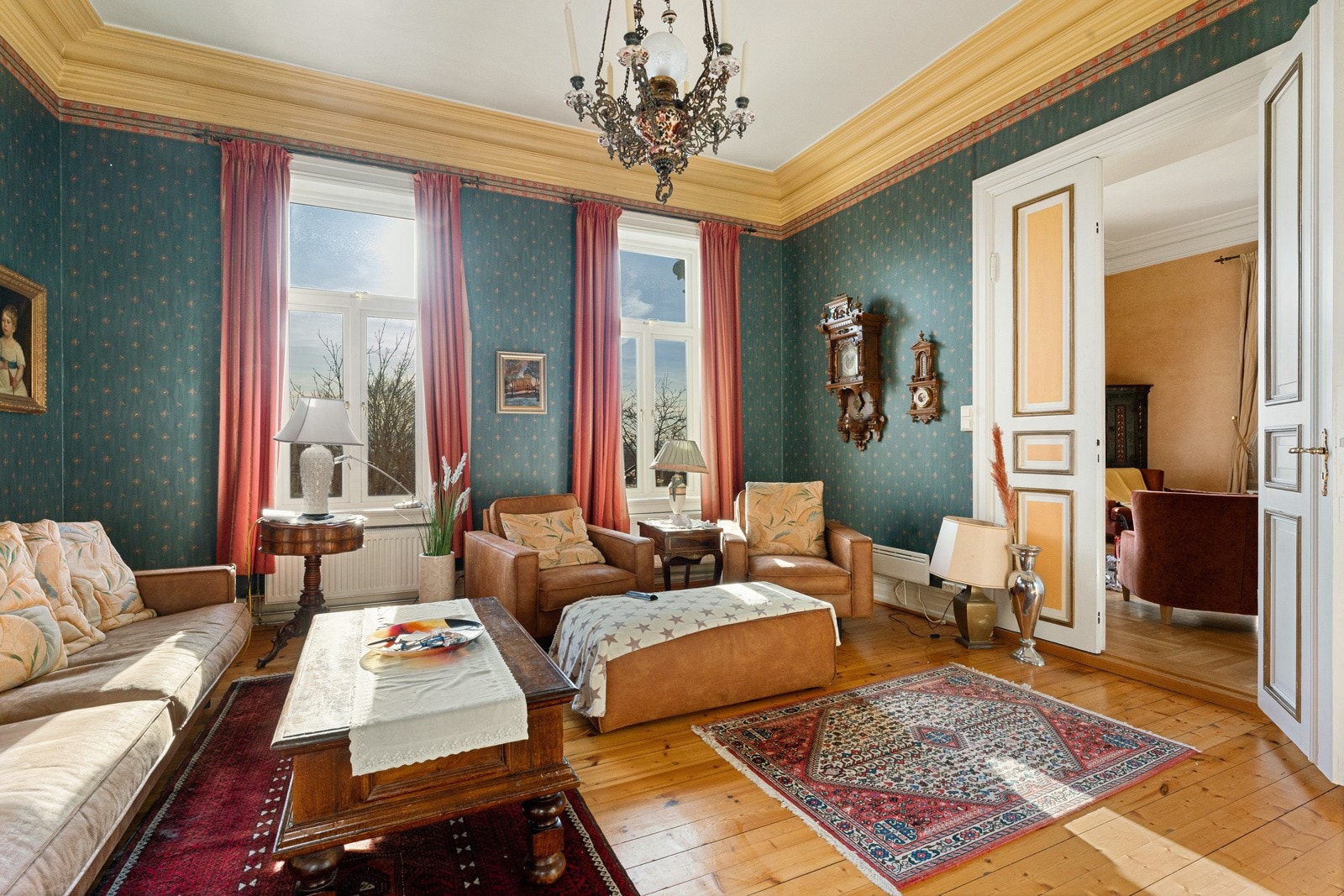 Mellom stuene er det en tofløyet, hvitprofilert dør, og store flaggpostvinduer fyller rommene med naturlig lys. I likhet med første etasje har også rommene en fantastisk takhøyde. Galleribilde