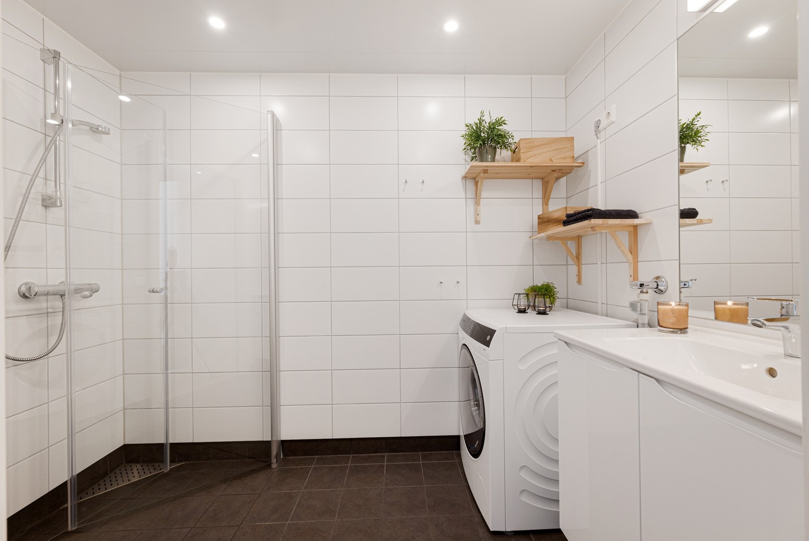 Badet har vegghengt toalett og et dusjhjørne med innfellbare vegger.