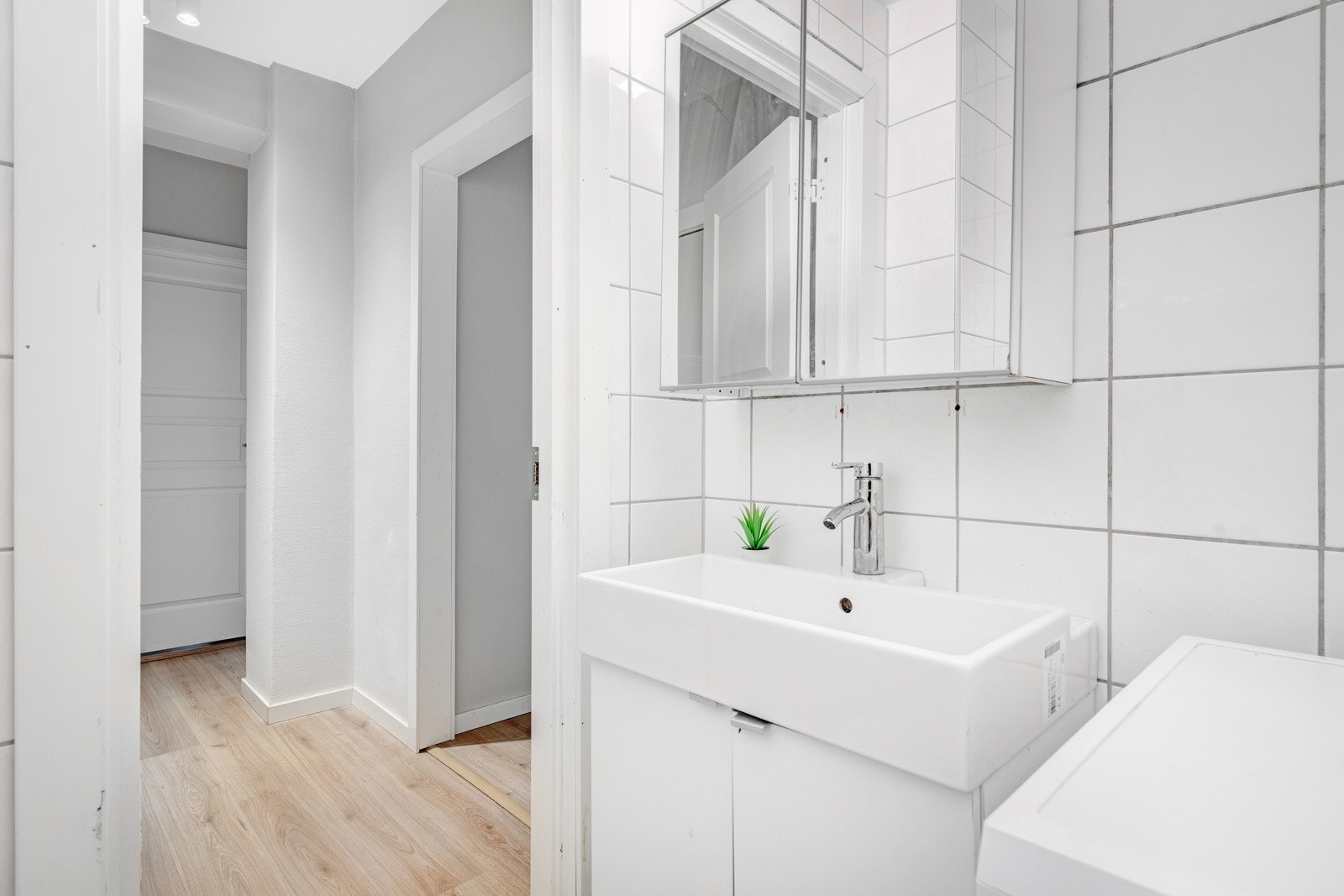 Badet har flislagte overflater, gulvvarme, åpent dusjhjørne, toalett og opplegg for vaskemaskin. Galleribilde