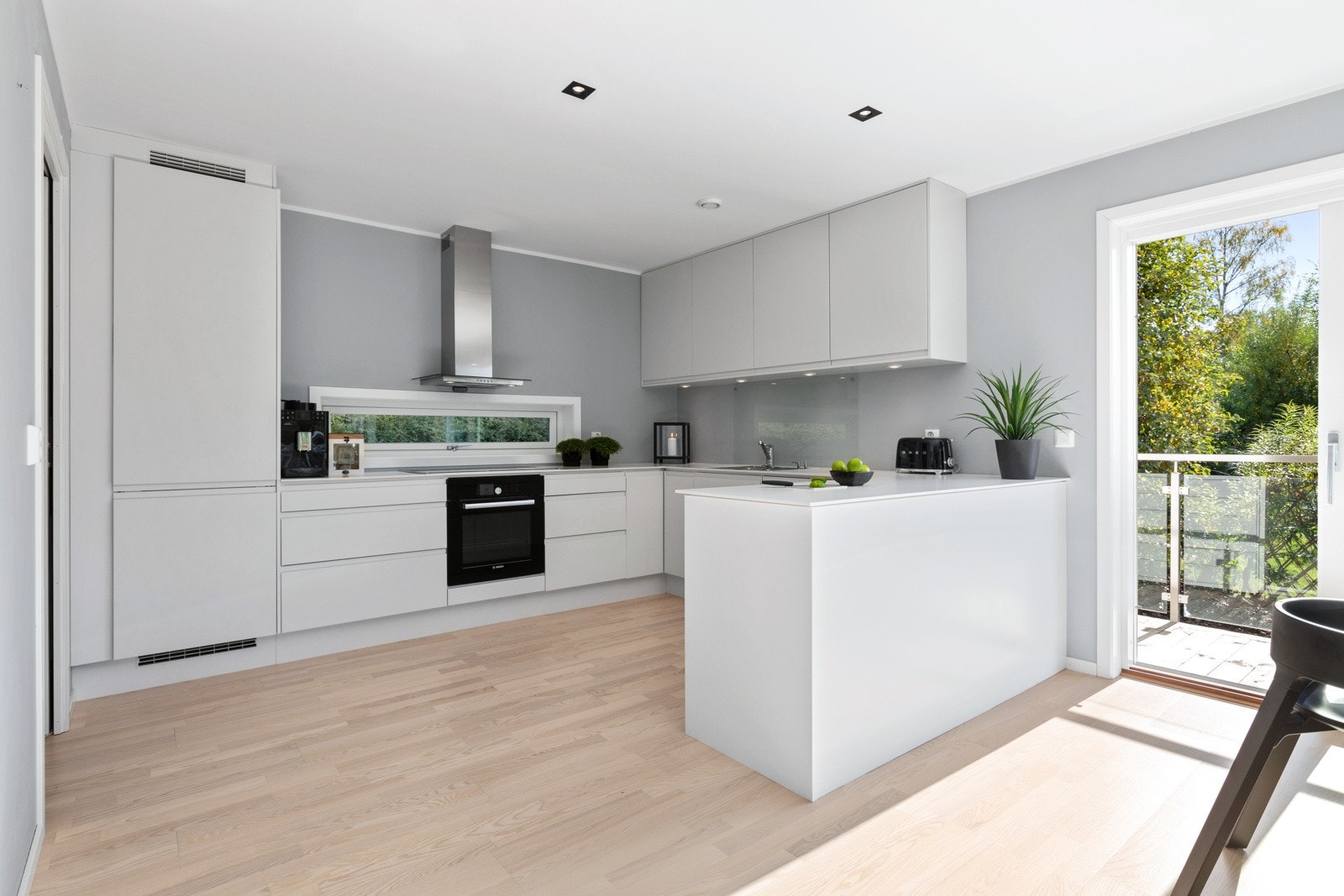 Boligen har et pent kjøkken med lyse slette fronter og benkeplate i laminat Galleribilde