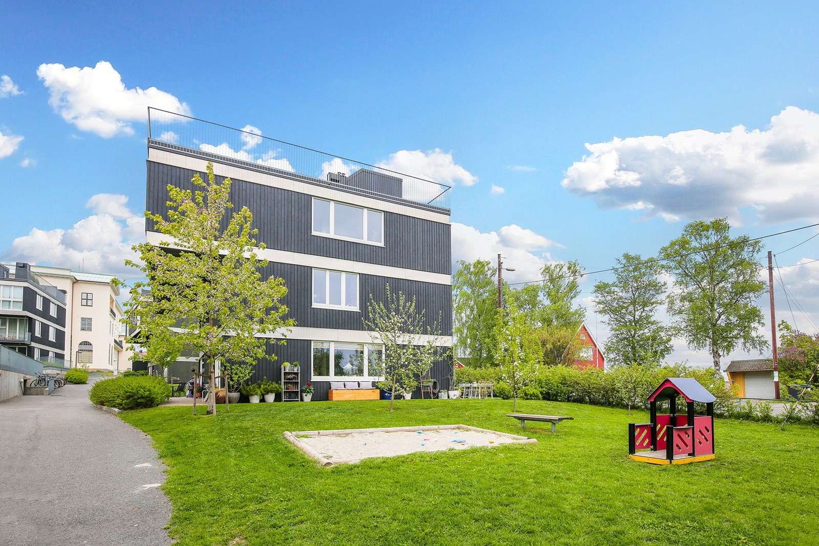 Sommerbilde av borettslaget - Området er pent beplantet og har fine gangstier mellom boenhetene. Galleribilde