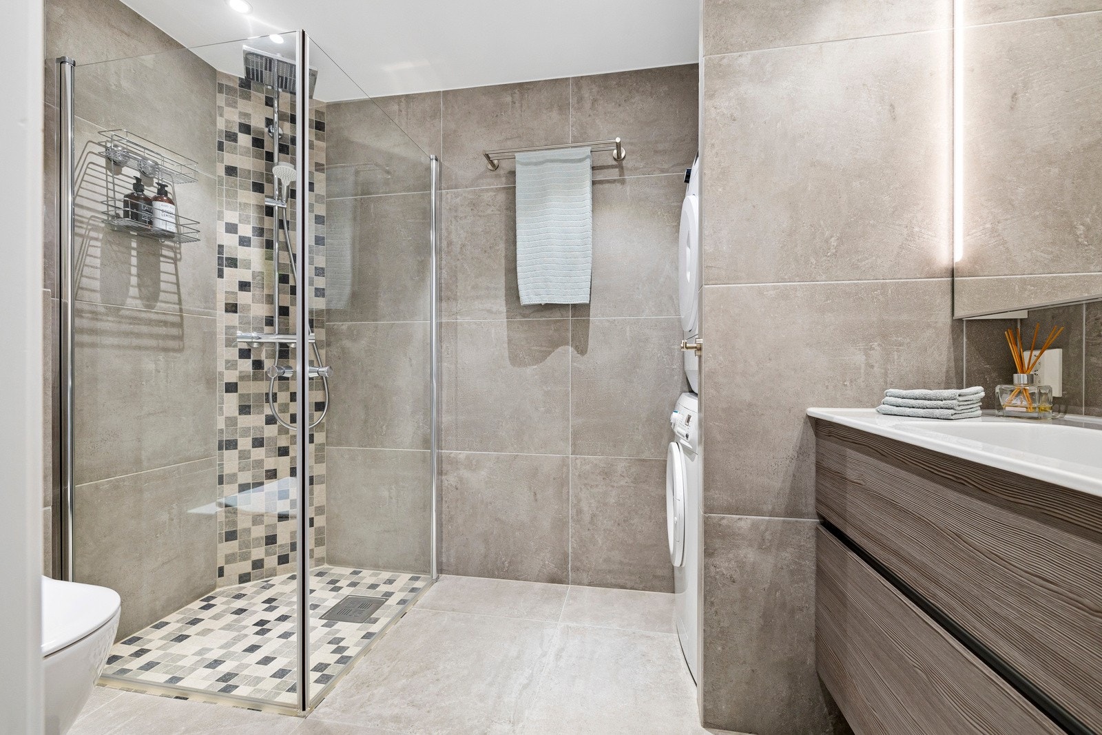 Pent flislagt baderom med gulvvarme renovert i 2018. Det er opplegg for både vaskemaskin og tørketrommel i egen nisje. Galleribilde