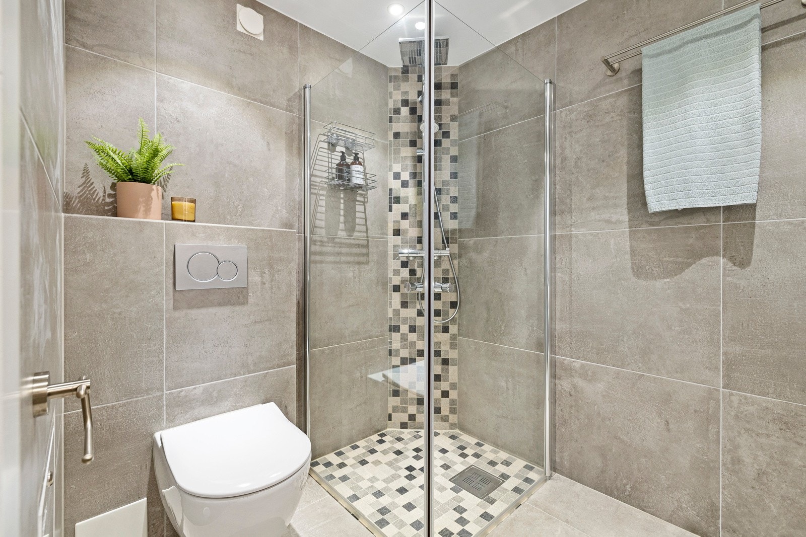 Baderommet er innredet med et vegghengt toalett, dusjhjørne med deilig regndusj, servantinnredning og speilskap med lys. Galleribilde