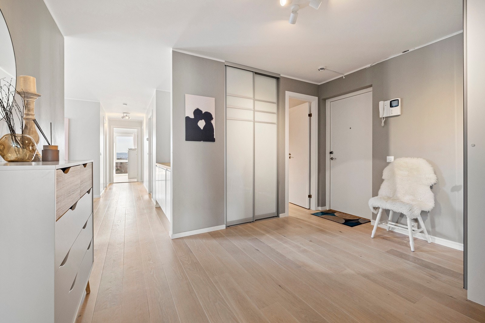 Praktisk skyvedørsgarderobe fra 2018 og speilskap i entré. Det er også adkomst til en innvendig bod med ytterligere lagringsplass. Det er montert callinganlegg med videooverføring. Galleribilde