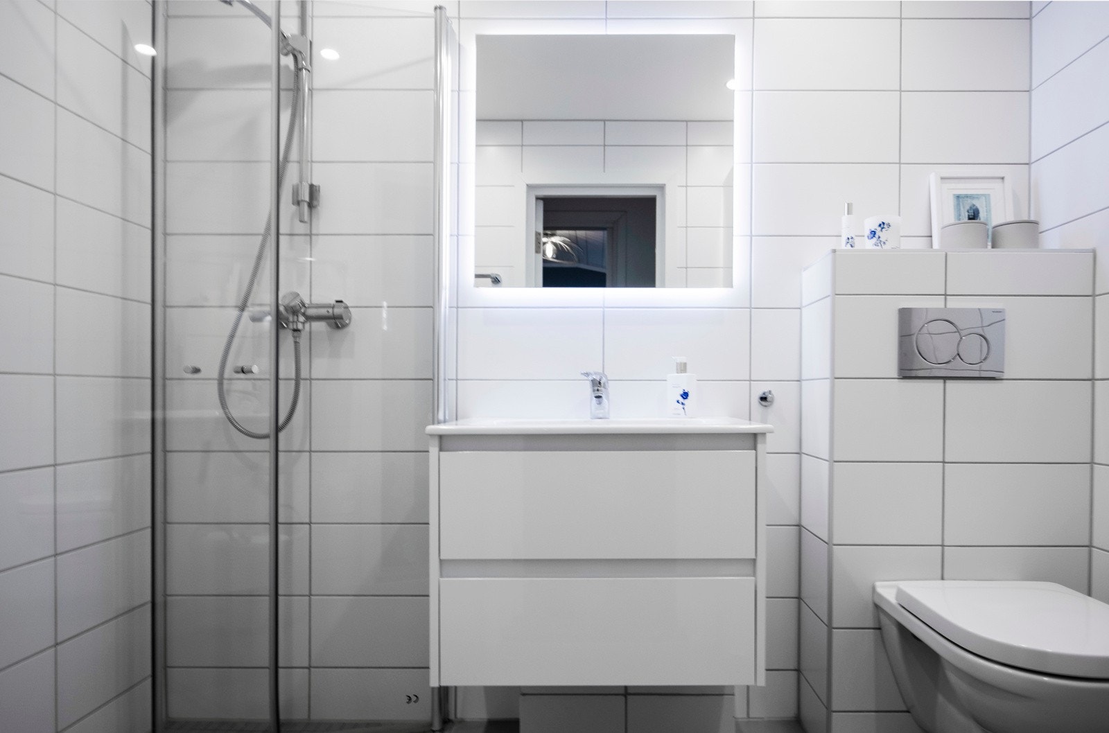 Baderom med flislagt gulv med varme og flislagte vegger. Nedsenket himling med downlights. Galleribilde