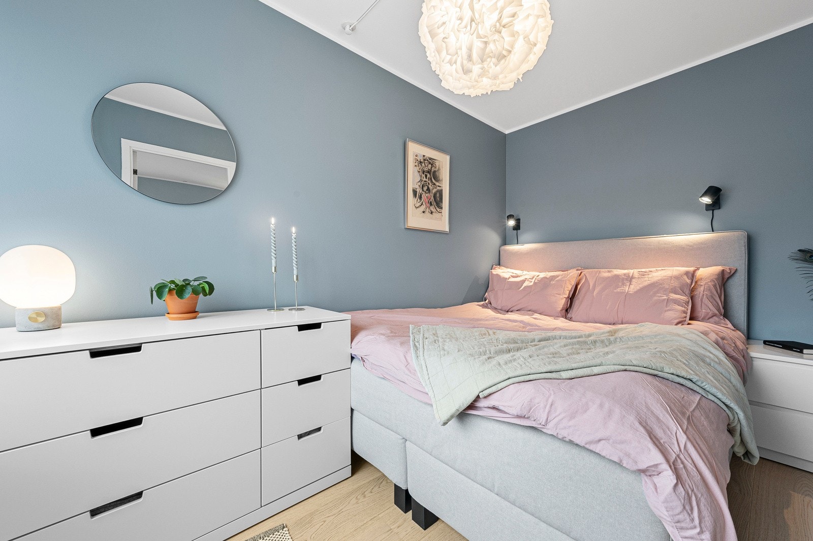 Leiligheten har et romslig soverom malt i en lun blåfarge. Rommet har plass til dobbeltseng og møblement for oppbevaring. Galleribilde