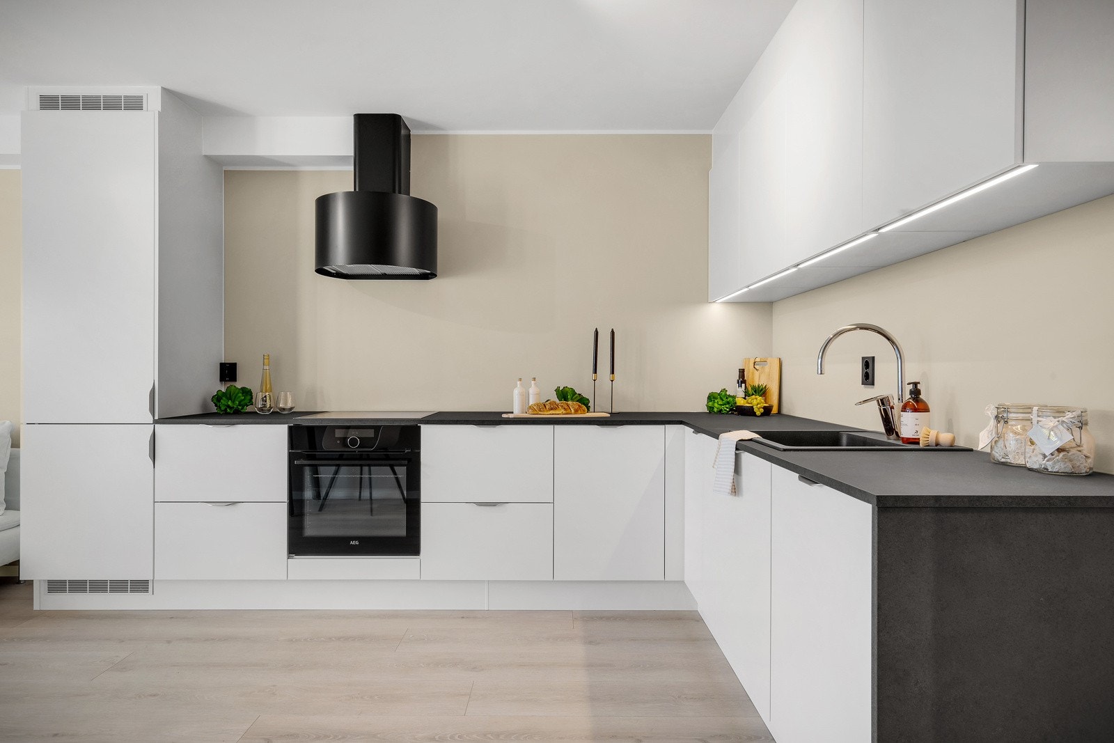 Moderne kjøkken med slette hvite fronter og laminert benkeplate. Galleribilde