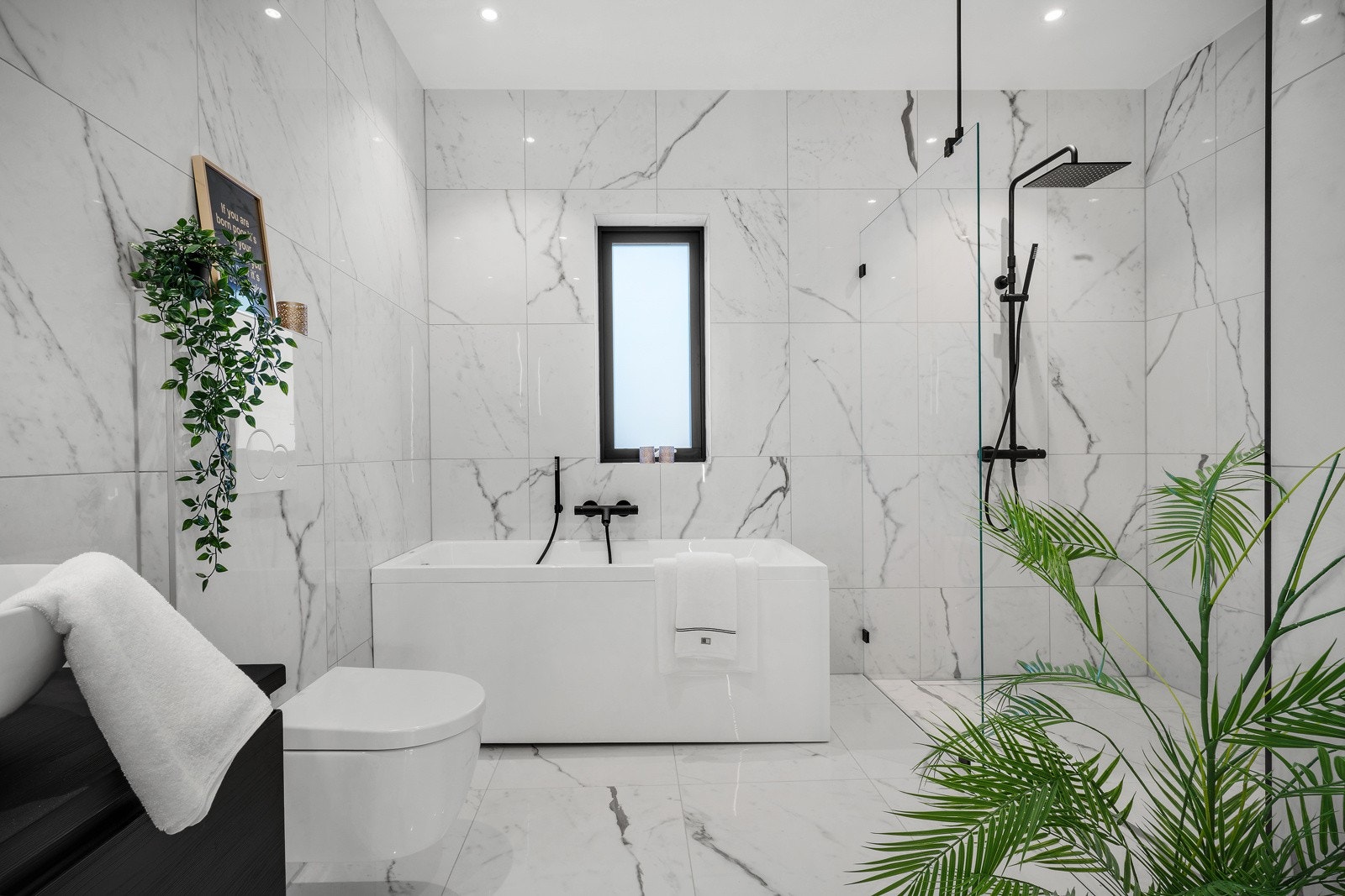 Badet er innredet med vegghengt wc, dusj med glassnisje, badekar, speil og belysning (spotlights i tak). Galleribilde