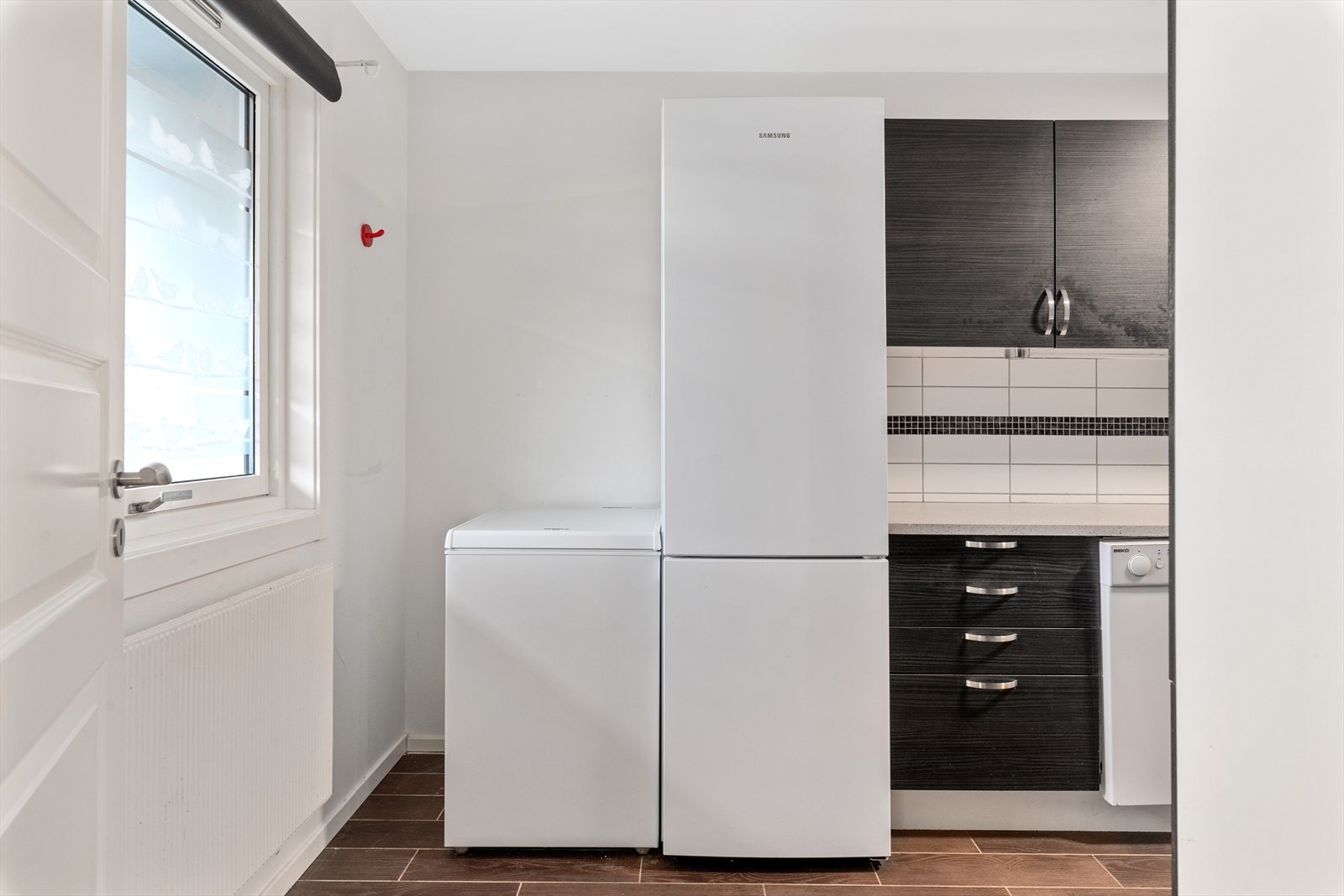 Kjøkkenet er separat og har innredning med finerte fronter, 2 fronter med glass, laminat benkeplater, oppvaskkum, hetteventilator, fliser over benk, belysning under overskap og opplegg for oppvaskmaskin. Galleribilde