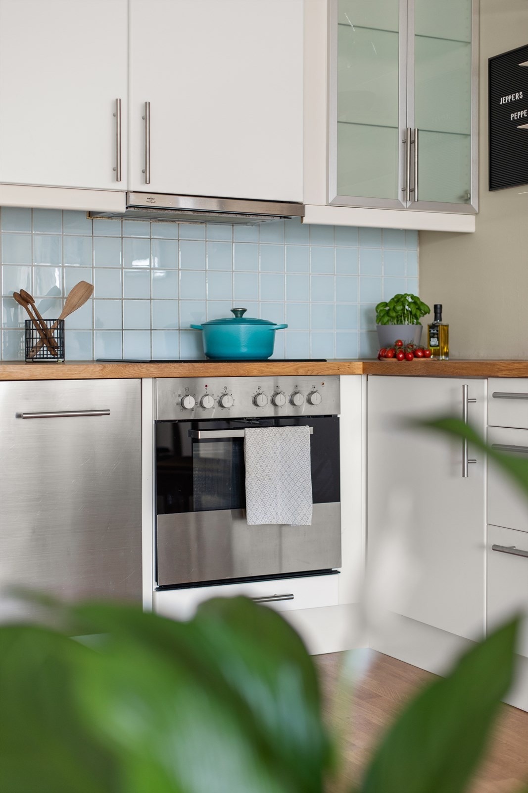 Kjøkkeninnredningen har hvite slette lakkerte fronter, heltre benkeplate med fliser over, enkel oppvaskkum, ventilator, oppvaskmaskin og komfyr. Galleribilde