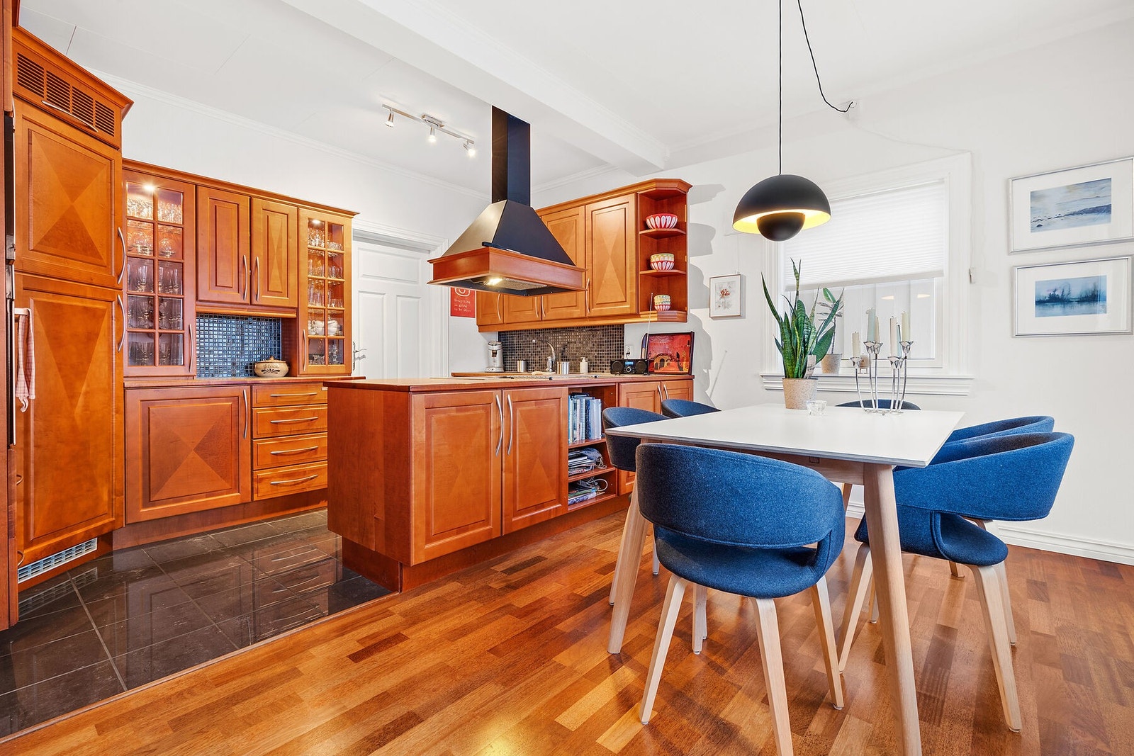 Flott kjøkken med plass for spisebord - døra fører inn til vaskerommet Galleribilde