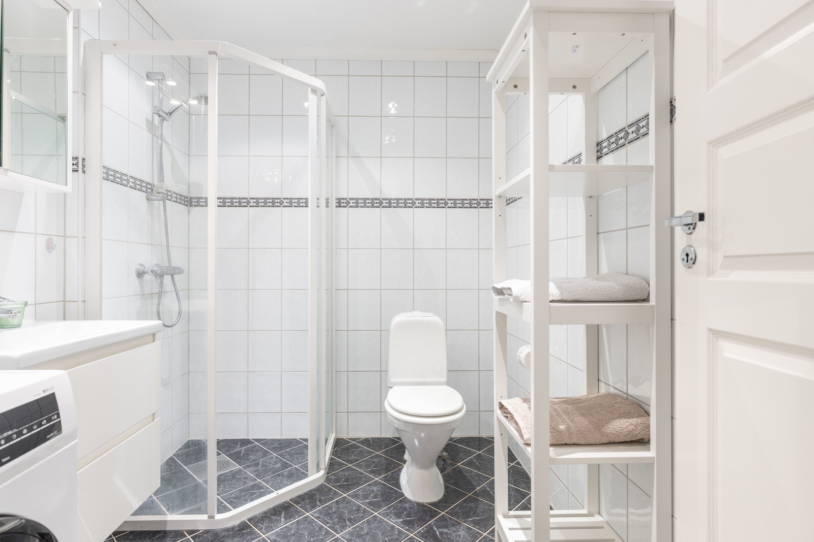 Flislagt bad innredet med dusj, toalett og servant Galleribilde