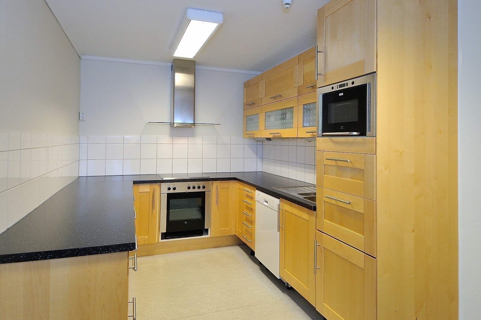 Kjøkken utstyrt med komfyr, kokeplater, vifte og kjøleskap Galleribilde