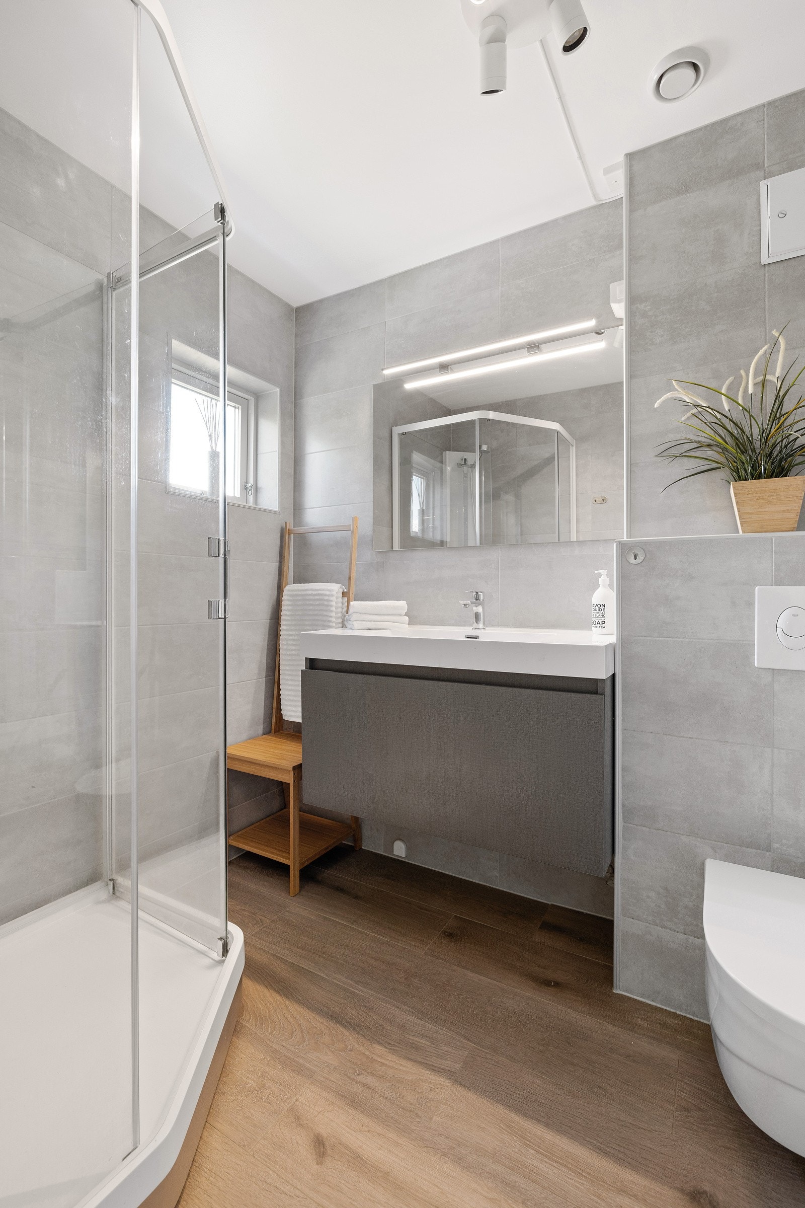 Bad i første etasje innredet med dusjkabinet, servant med skuffeseksjon og vegghengt klosett. Galleribilde