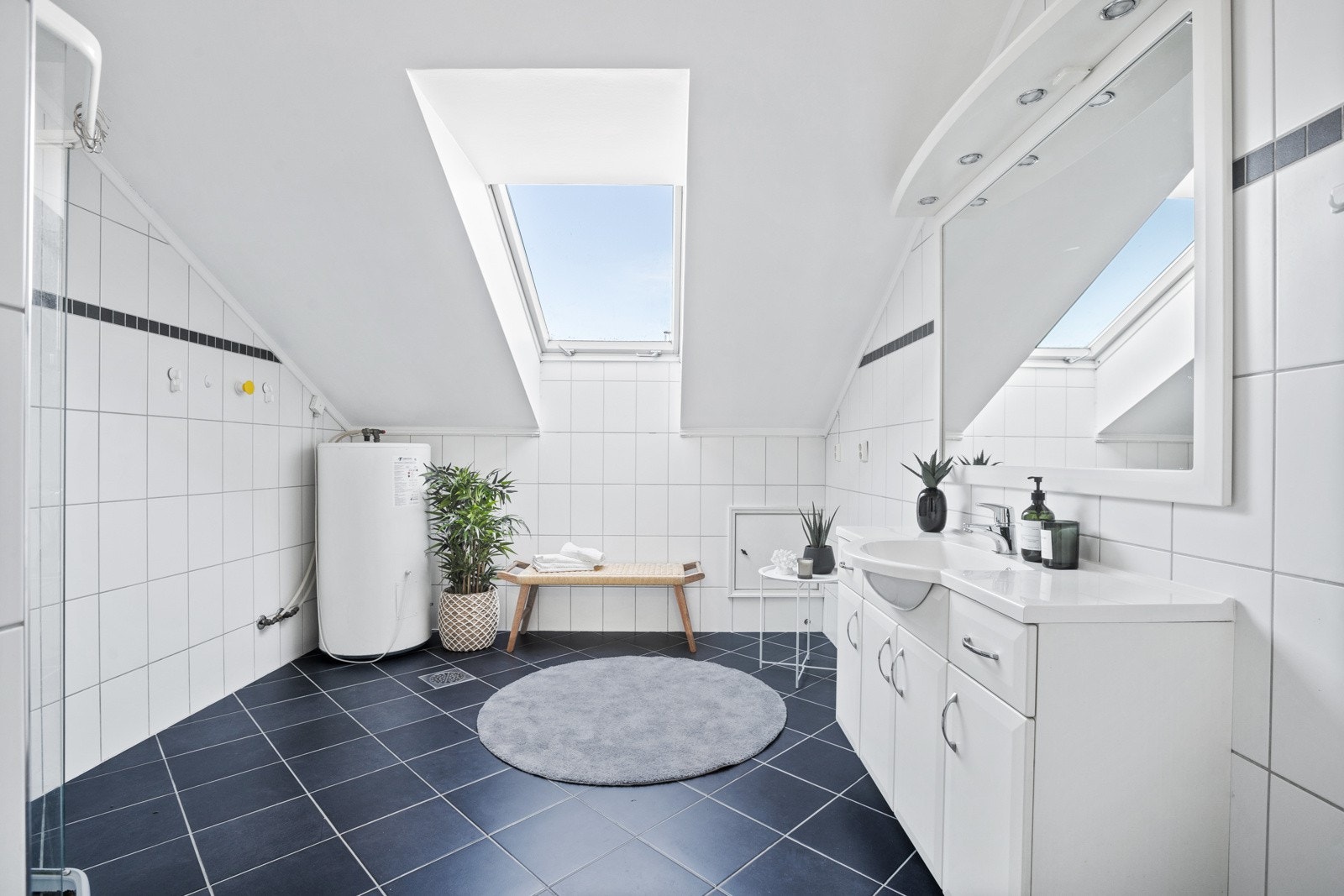 Pent, flislagt baderom fra 2005 som er både tidløst, praktisk og romslig. Galleribilde