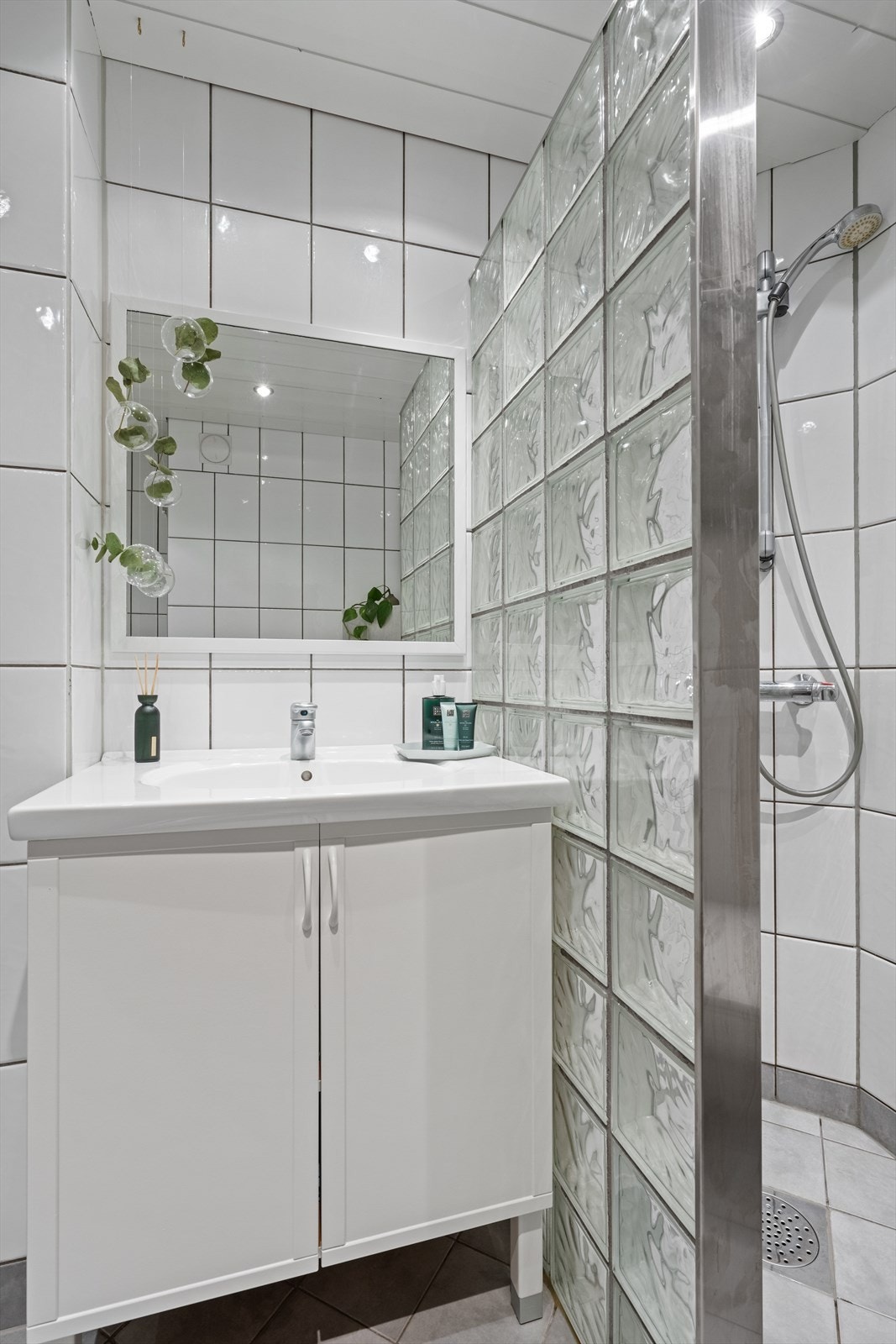 Baderommet er innredet med dusjsone, toalett og servant med servantskap. Galleribilde