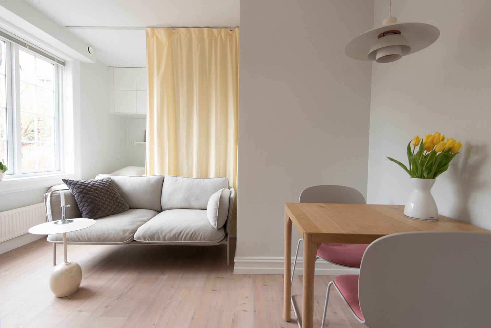 Spiseplass, sofa. Sovealkove bak gardin Galleribilde