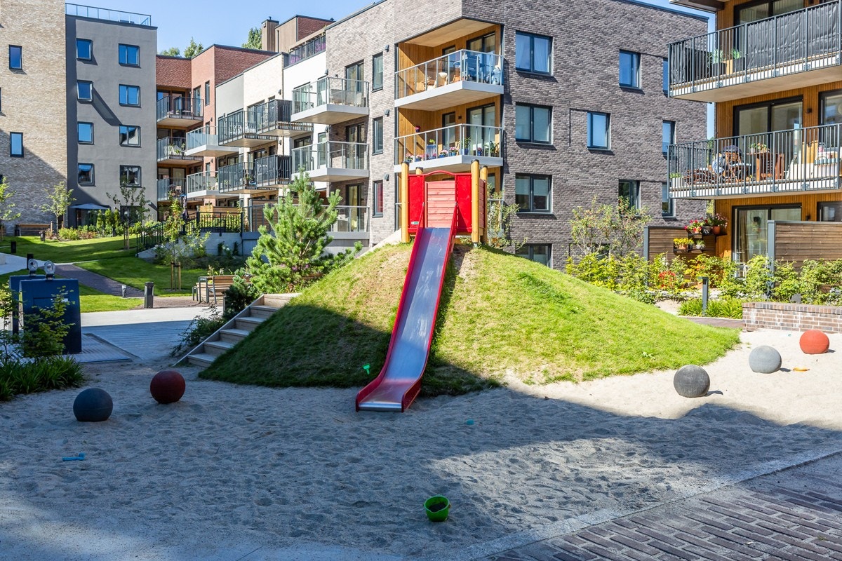 Mellom husene er det laget plass for lek og moro Galleribilde