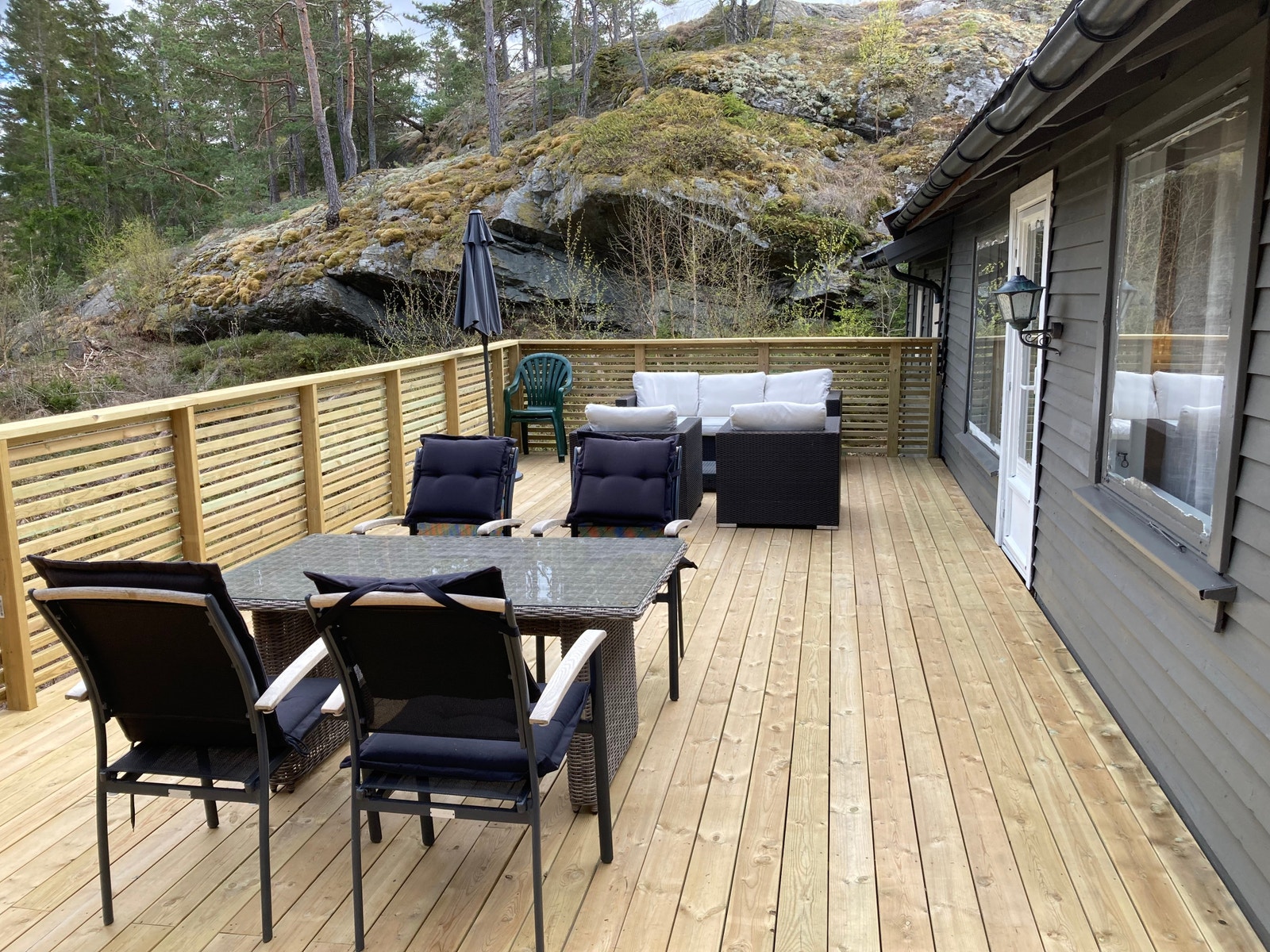 Terrasse forside med kullgrill hengekøye og parasoll. Galleribilde