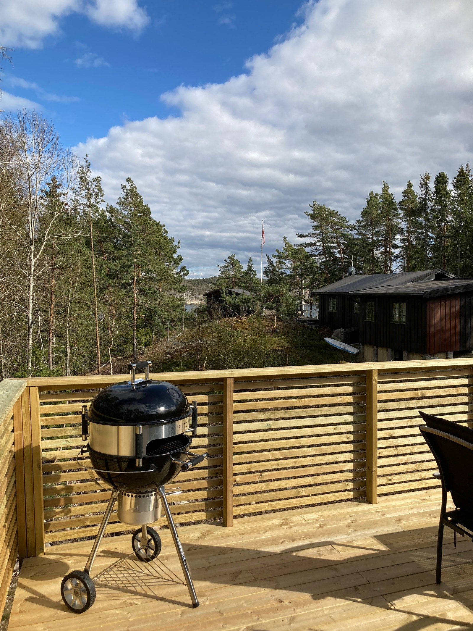Terrasse forside med kullgrill hengekøye og parasoll. Galleribilde