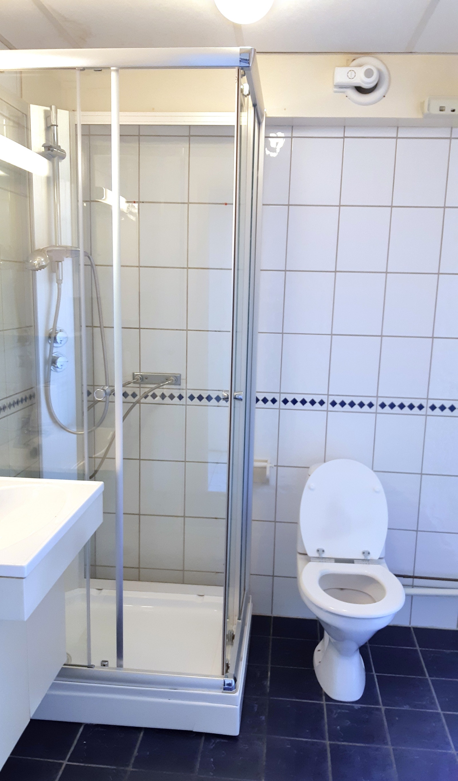 Flislagt bad med dusjkabinett og plass til vask og tørk. Galleribilde